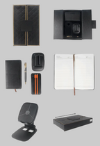 Collage of black office supplies including a notebook, pen holder, power bank and phone stand on a white background.